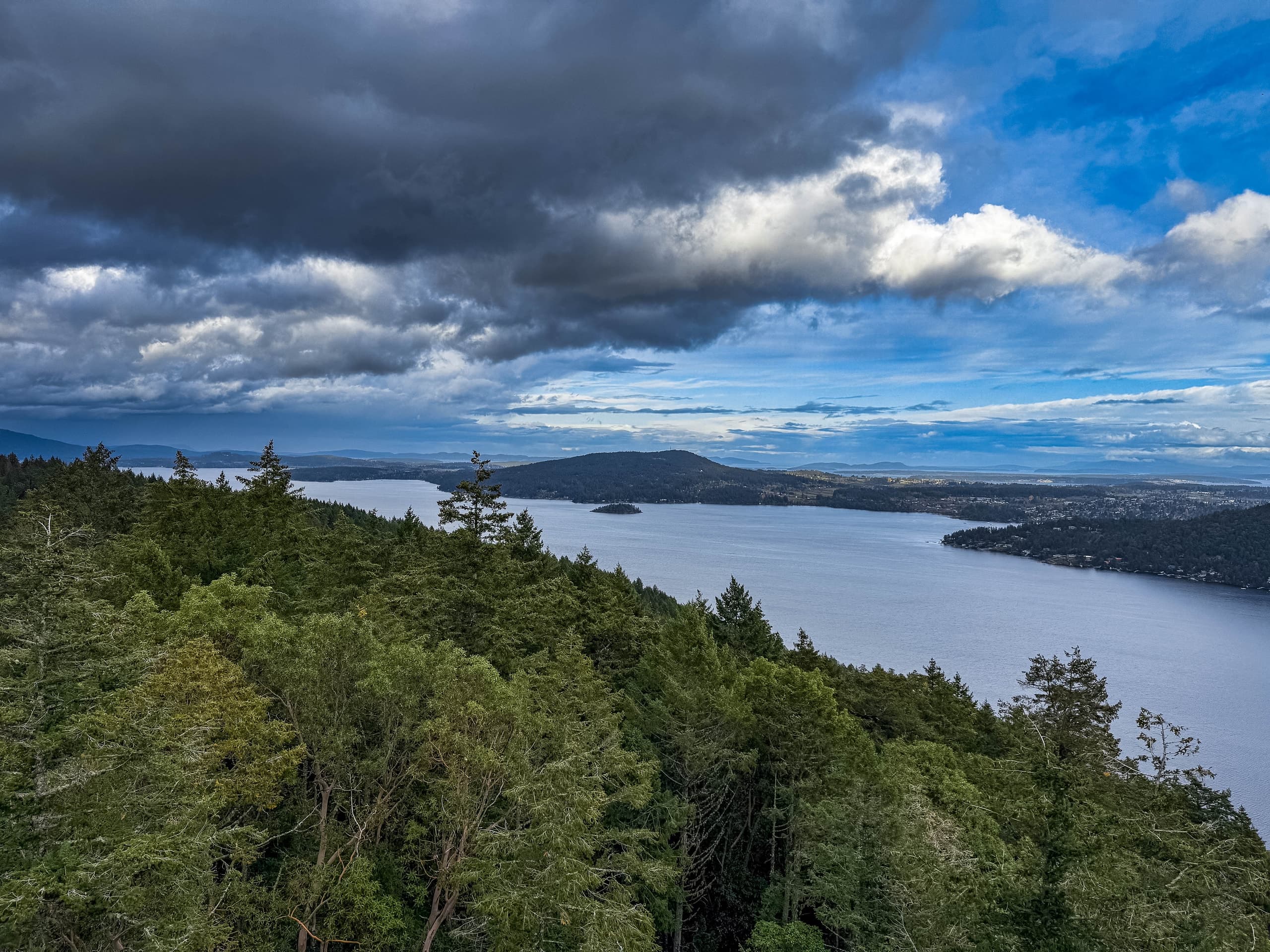 Storm light over forest, islands, and the inlet from the Malahat