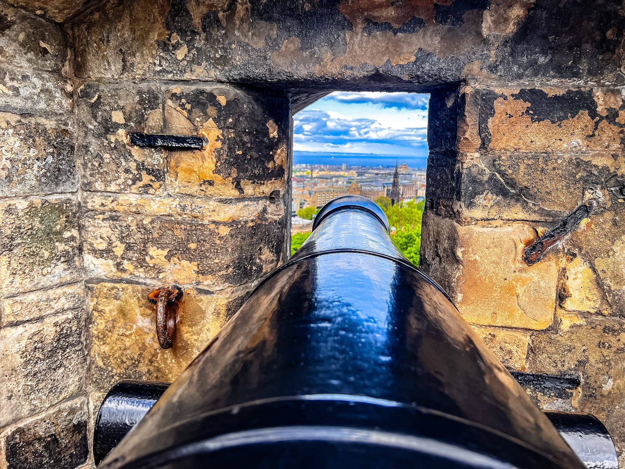 A cannon in an embrasure looking out over Edinburgh and the Scott Monument