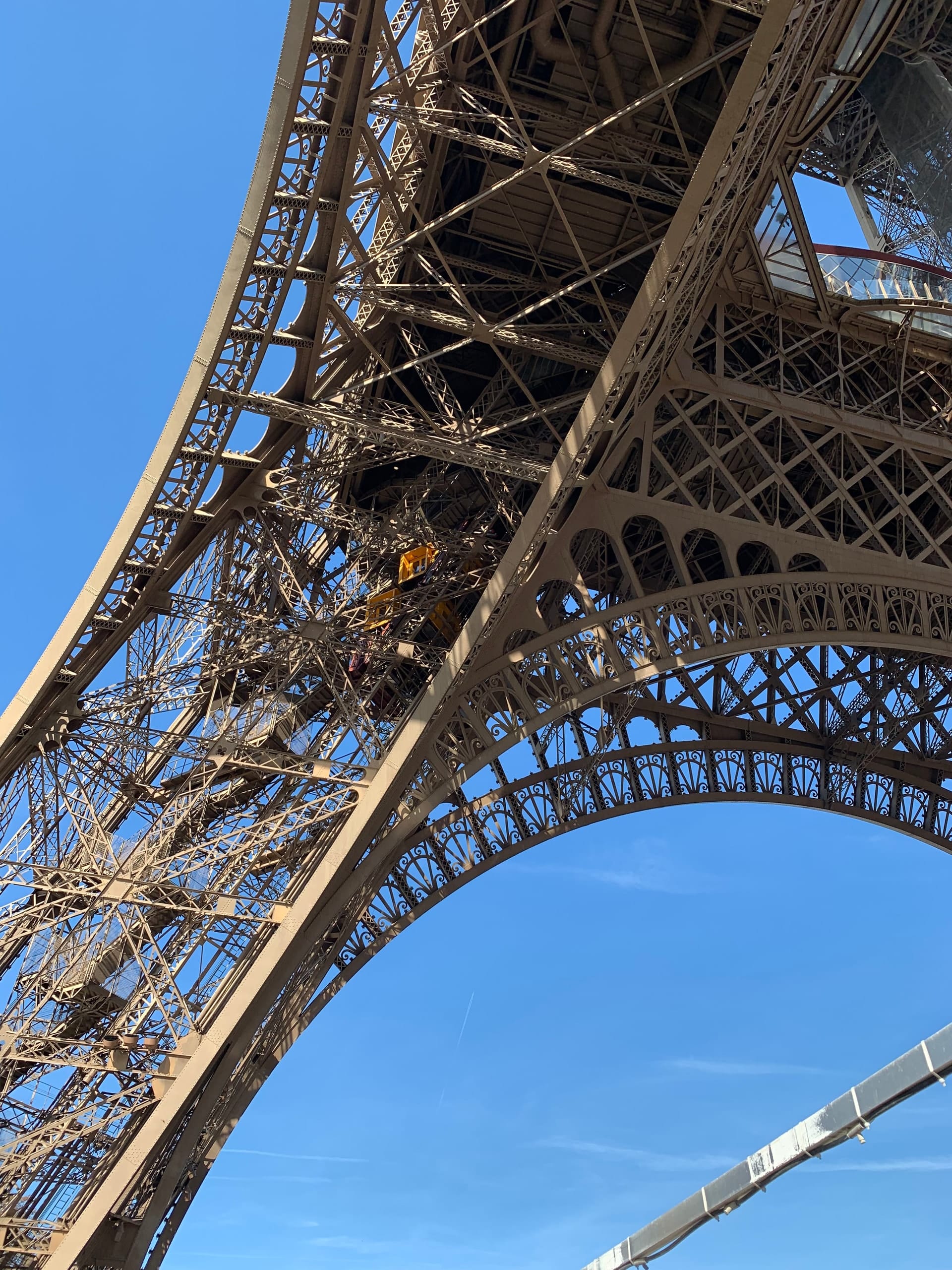 The iron lattice of the Eiffel Tower against a clear sky