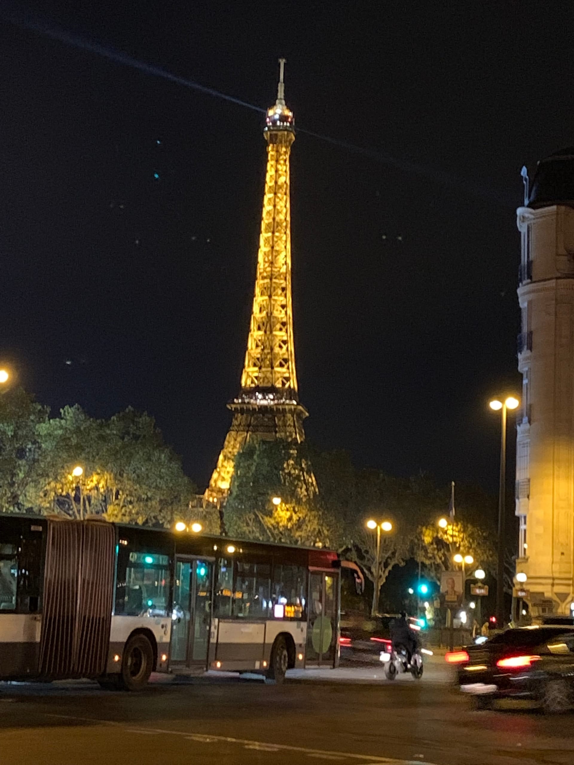 The Eiffel Tower lit gold above a Paris street