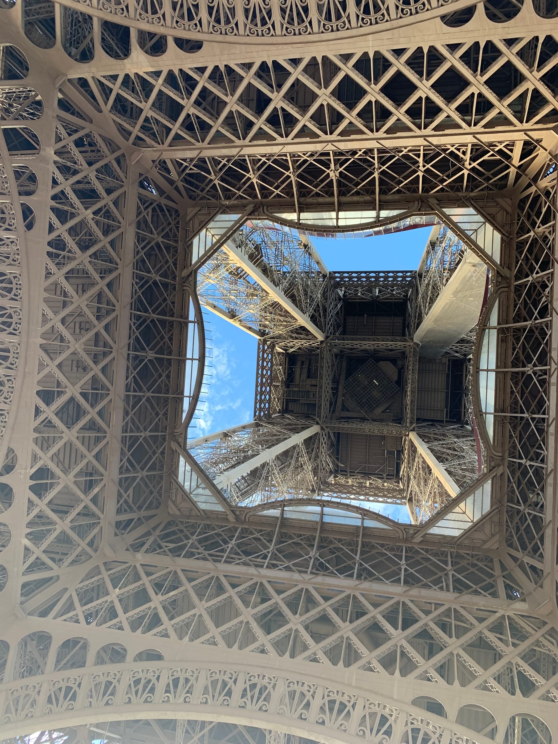 Looking straight up through the ironwork of the Eiffel Tower