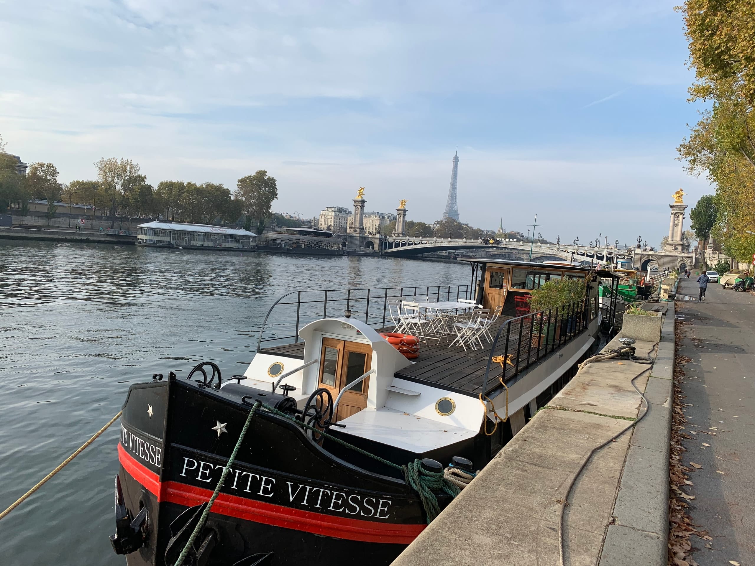 The barge Petite Vitesse on the Seine, with the Eiffel Tower in the distance